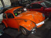 Oranje Volkswagen kever met flinke schade